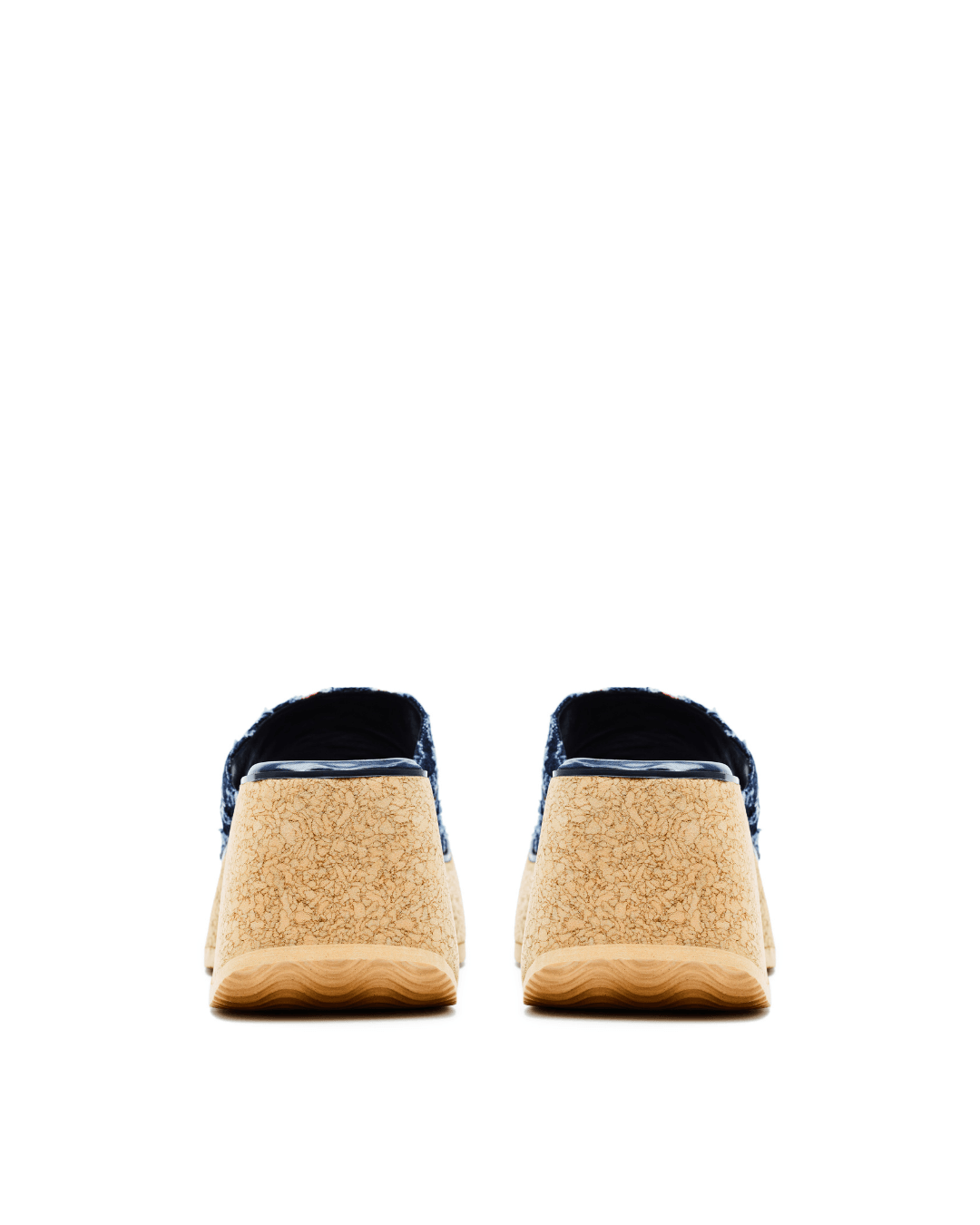 Pair of platform slide sandals with tan textured soles and dark upper on white background