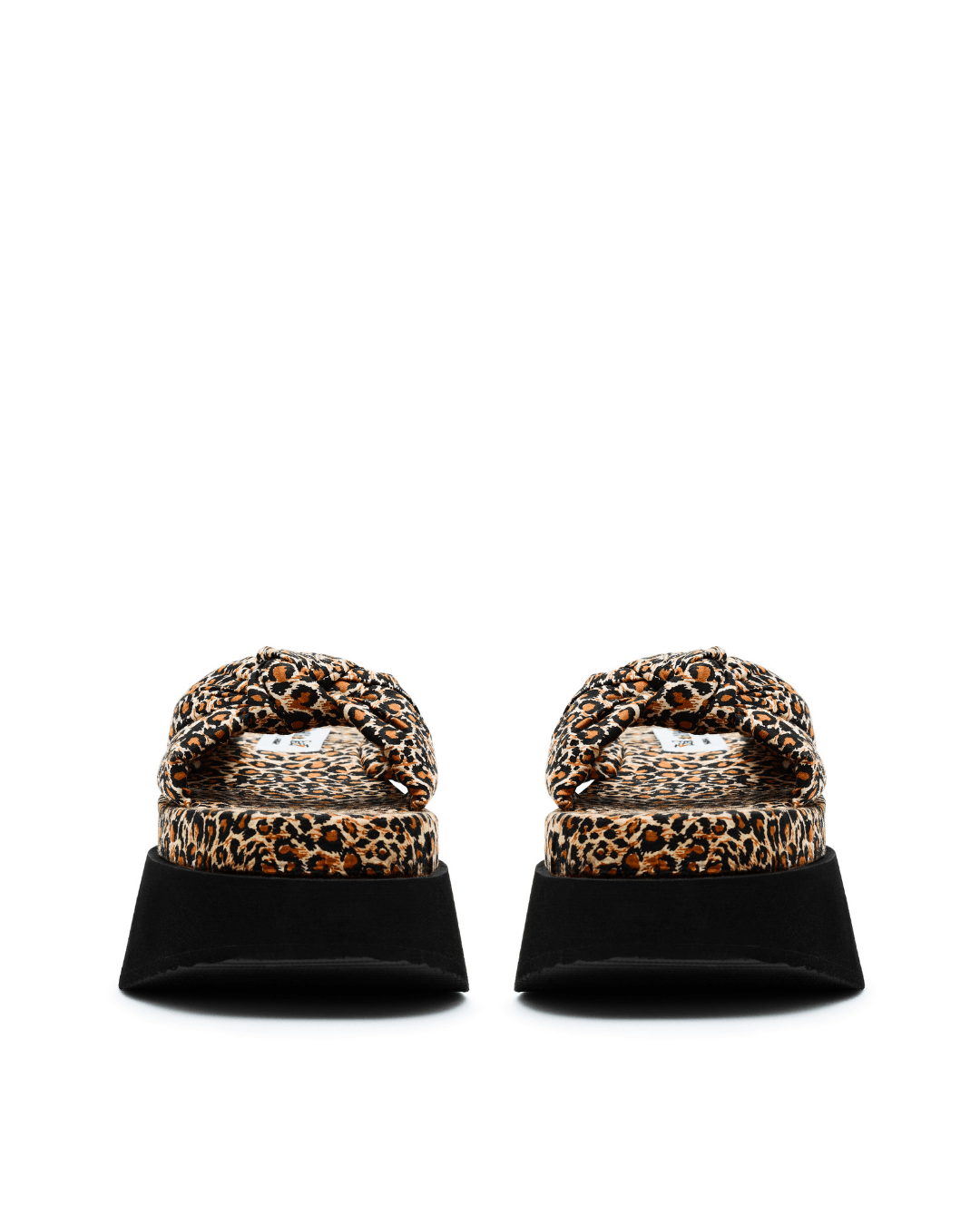 Pair of leopard print platform slide sandals with black soles on a white background