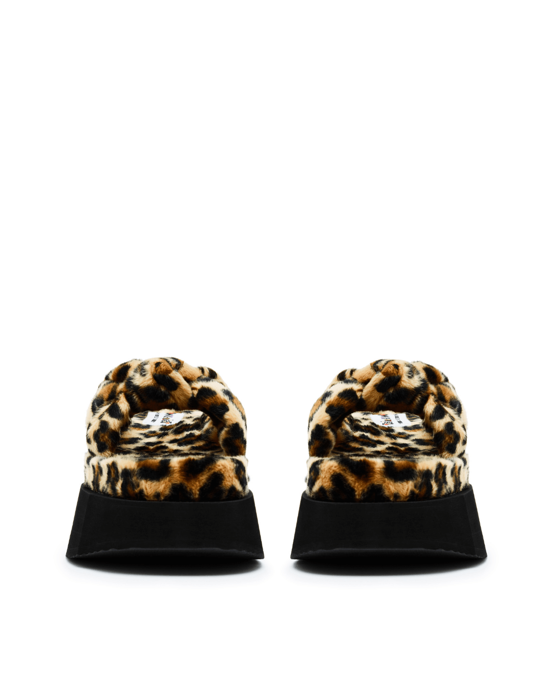Pair of faux fur platform slide sandals with leopard print and black soles on white background