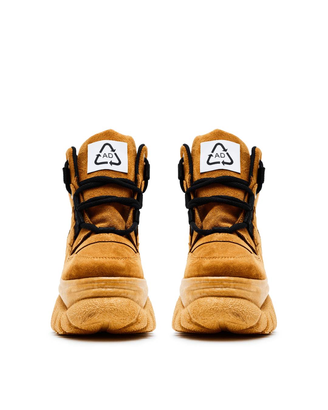 Pair of tan suede platform sneakers with black laces and chunky soles on white background