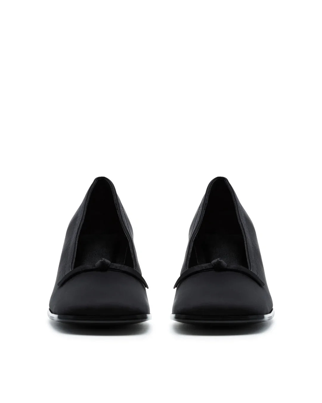 pair of black satin pumps with low heels and bow detail on white background