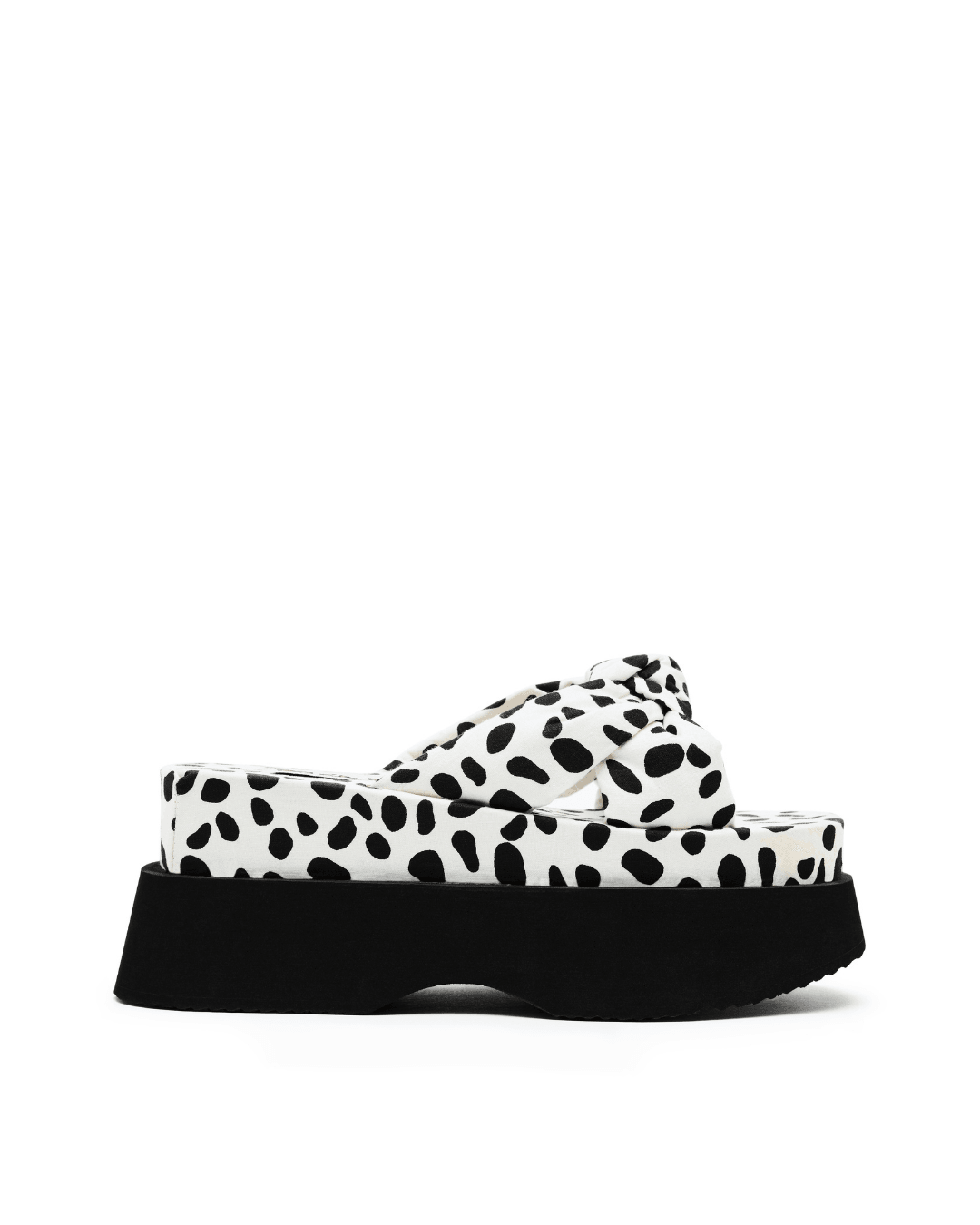 Black and white spotted platform slide sandal with thick black sole on white background