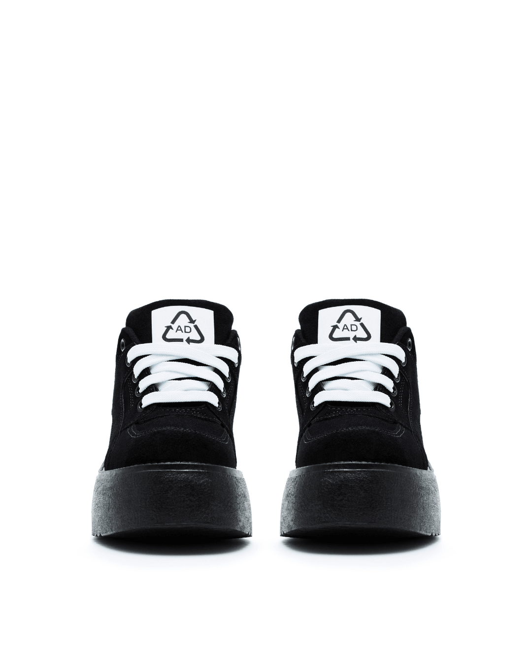 Black platform sneakers with white laces and thick rubber soles on a white background