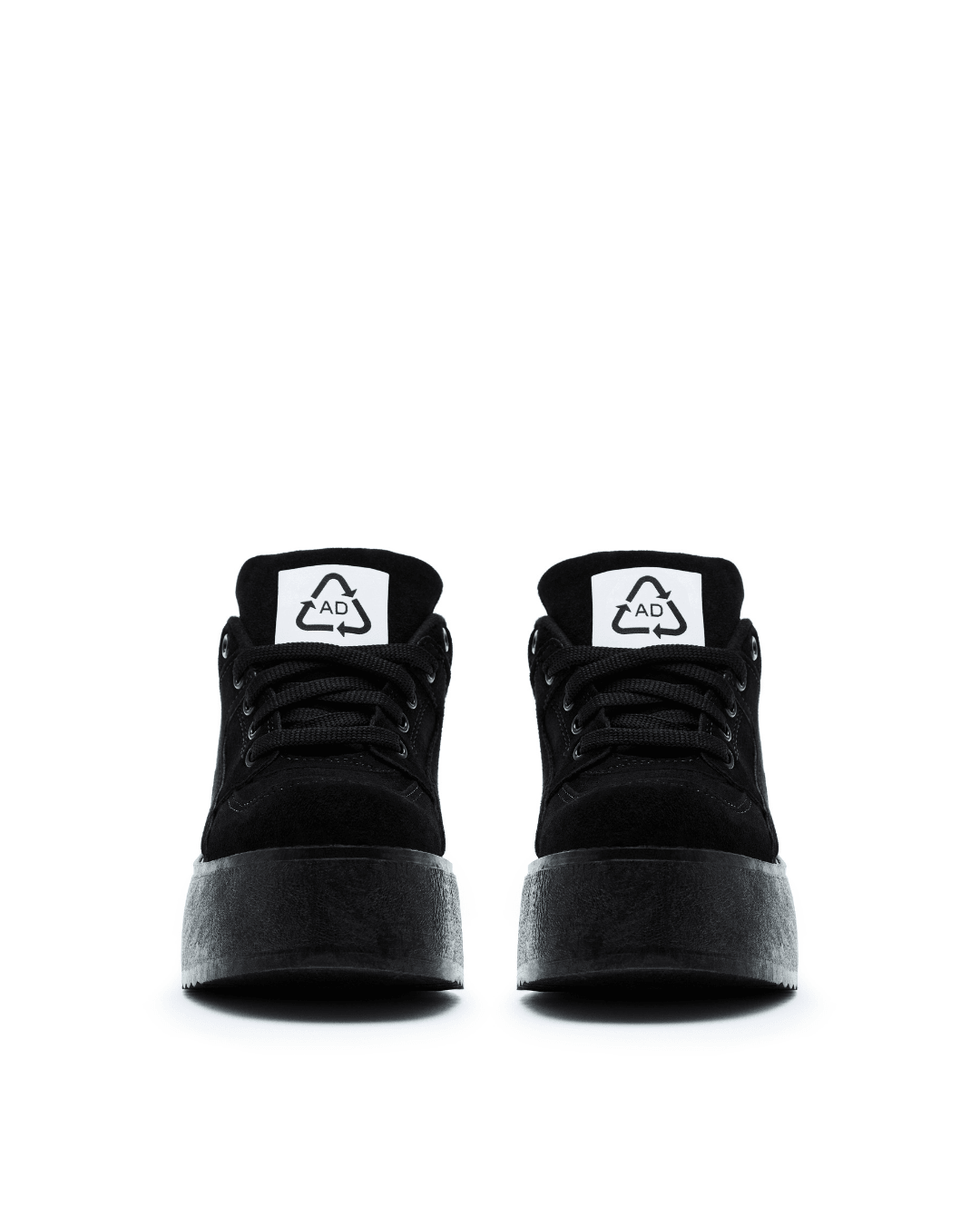 black platform sneakers with thick soles and white tongue labels on white background
