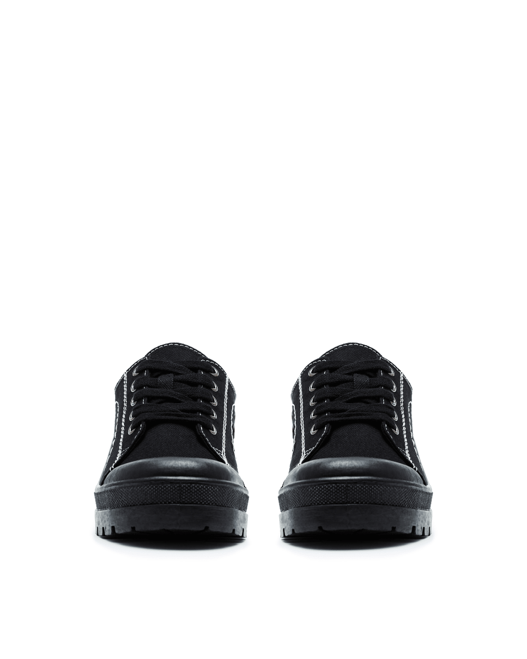 Pair of black canvas lace-up sneakers with thick rubber soles on white background