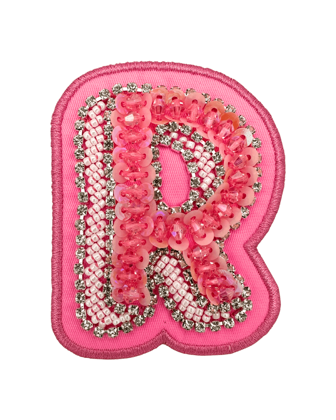 Pink embellished letter R patch with sequins, beads, and rhinestones on fabric