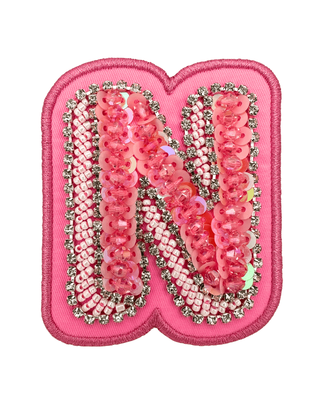 pink embroidered letter patch with sequins and beads on fabric background
