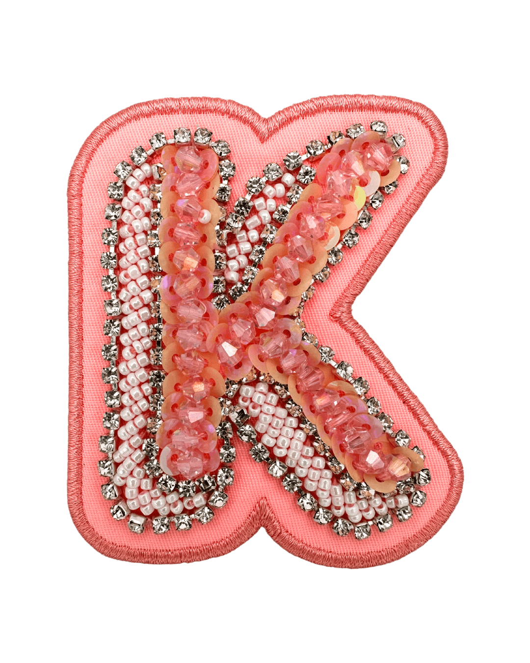 Embellished pink letter K patch with sequins, beads, and rhinestones on fabric