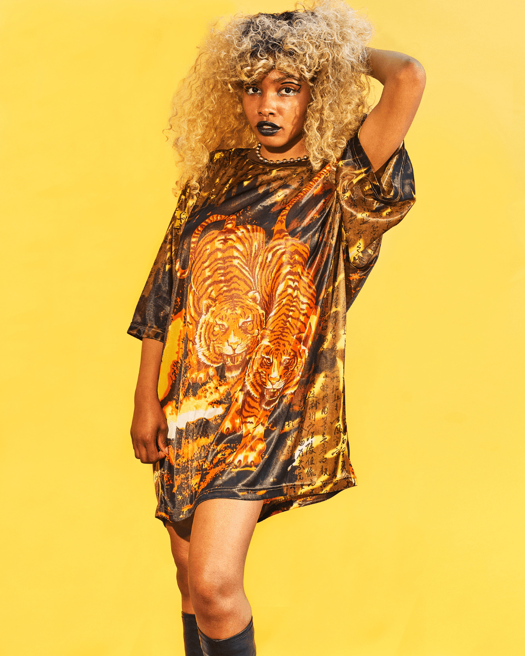 Woman wearing oversized black and orange t-shirt dress with tiger graphic and gold script