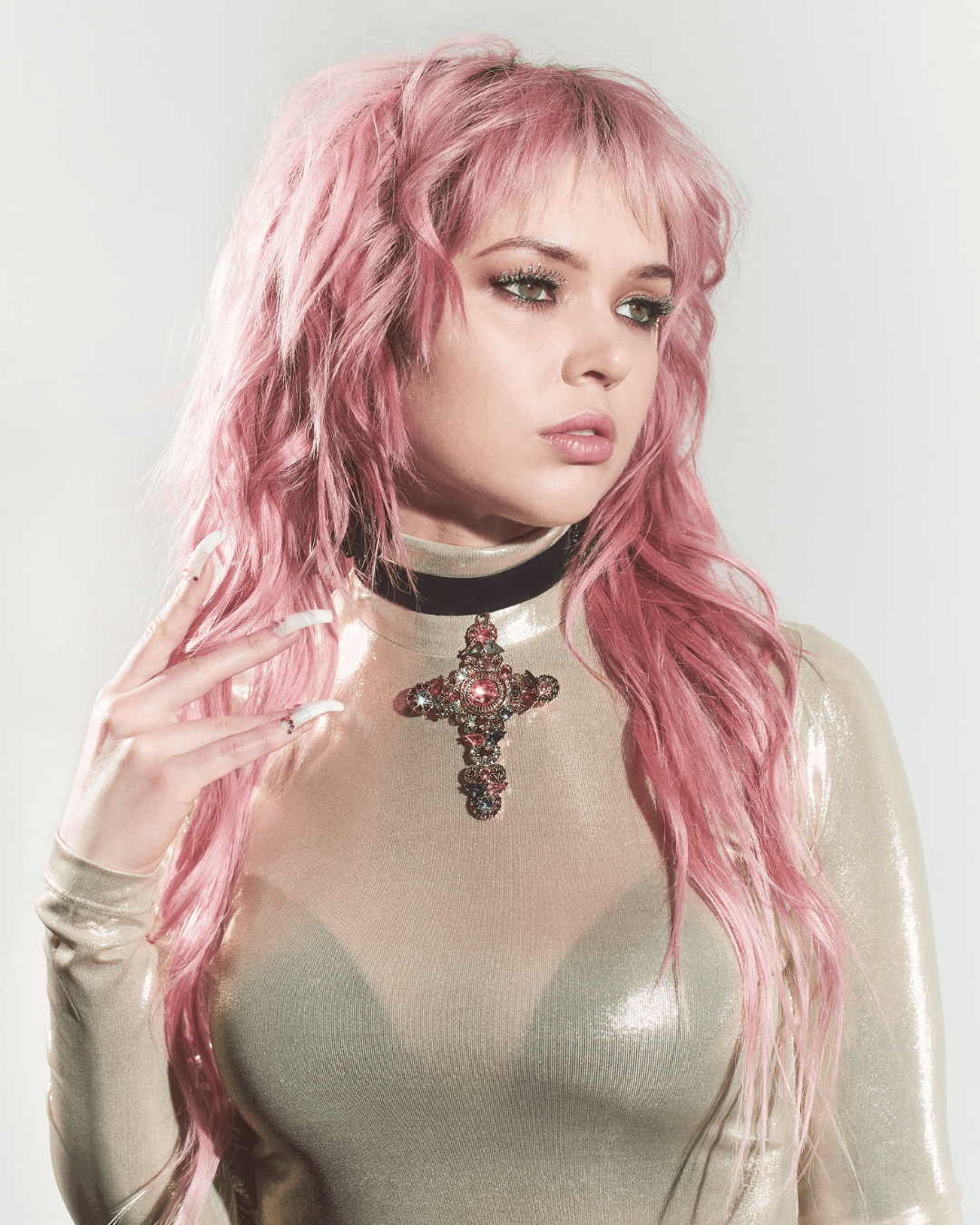 woman with pink hair wearing black velvet choker with large jeweled cross pendant
