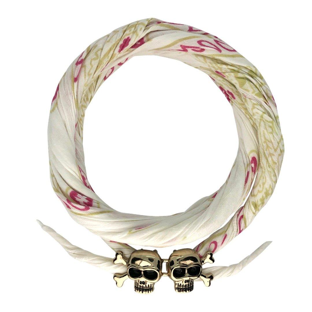 White patterned bandana with gold skull and crossbones clasp, twisted in a loop