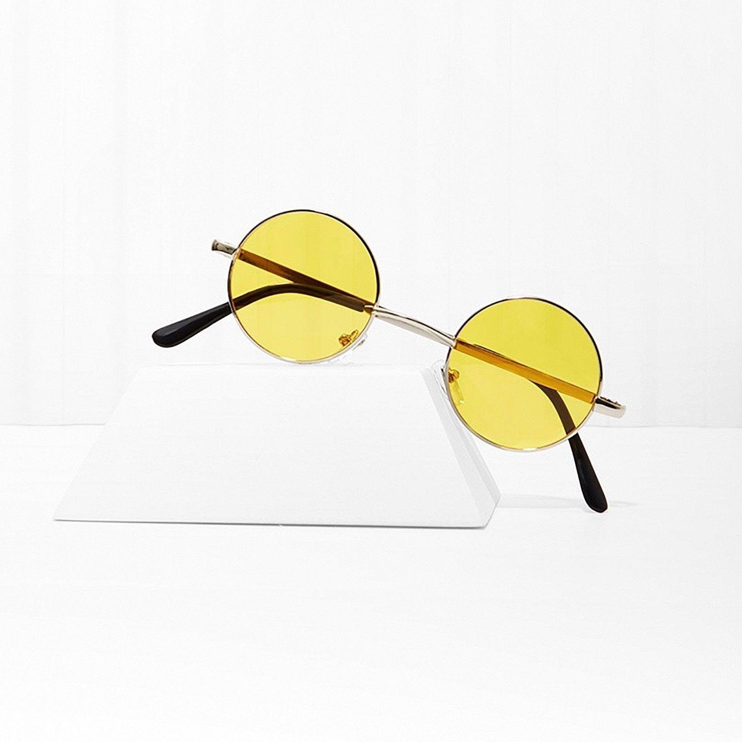 Round yellow lens sunglasses with metal frame on a white display block