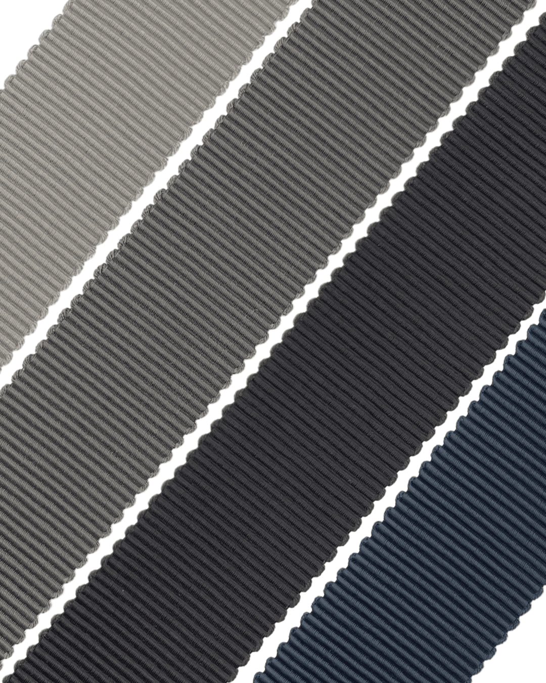 Four rolls of grosgrain ribbon in grey, dark grey, charcoal, and navy blue on white background